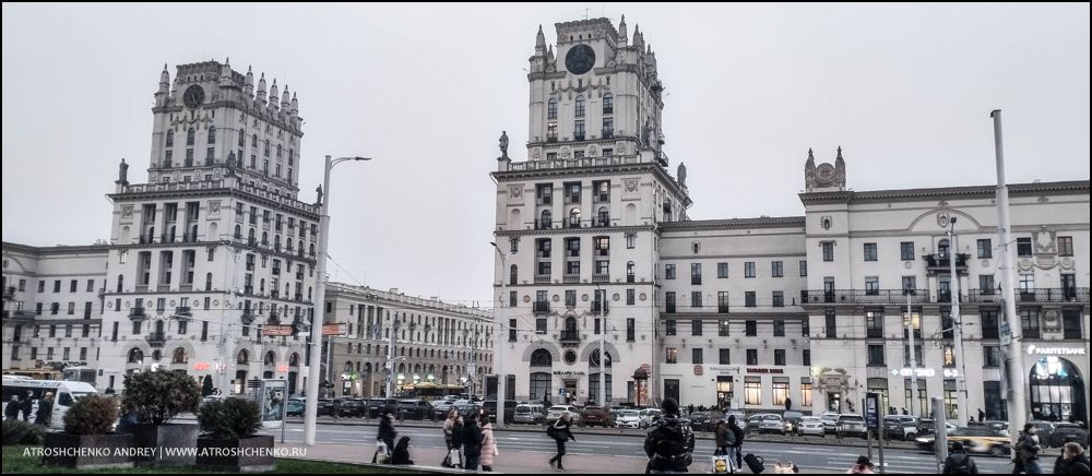 Комфортабельный автобус Ecolines на остановке в Минске на маршруте в Санкт-Петербург, вечерняя посадка пассажиров, вид на железнодорожный вокзал и архитектуру близ площади Бобруйской, начало романтического путешествия между Беларусью и культурной столицей России