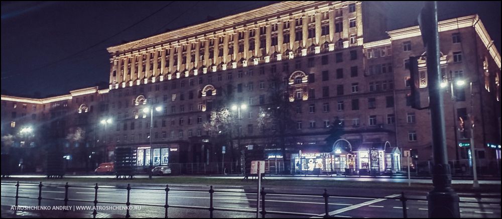 Комфортабельный автобус Ecolines на остановке в Минске на маршруте в Санкт-Петербург, вечерняя посадка пассажиров, вид на железнодорожный вокзал и архитектуру близ площади Бобруйской, начало романтического путешествия между Беларусью и культурной столицей России