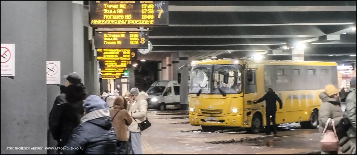 Современный автобус компании Ecolines на 4-й платформе минского автовокзала перед рейсом Санкт-Петербург, полный салон пассажиров вечером в конце новогодних праздников