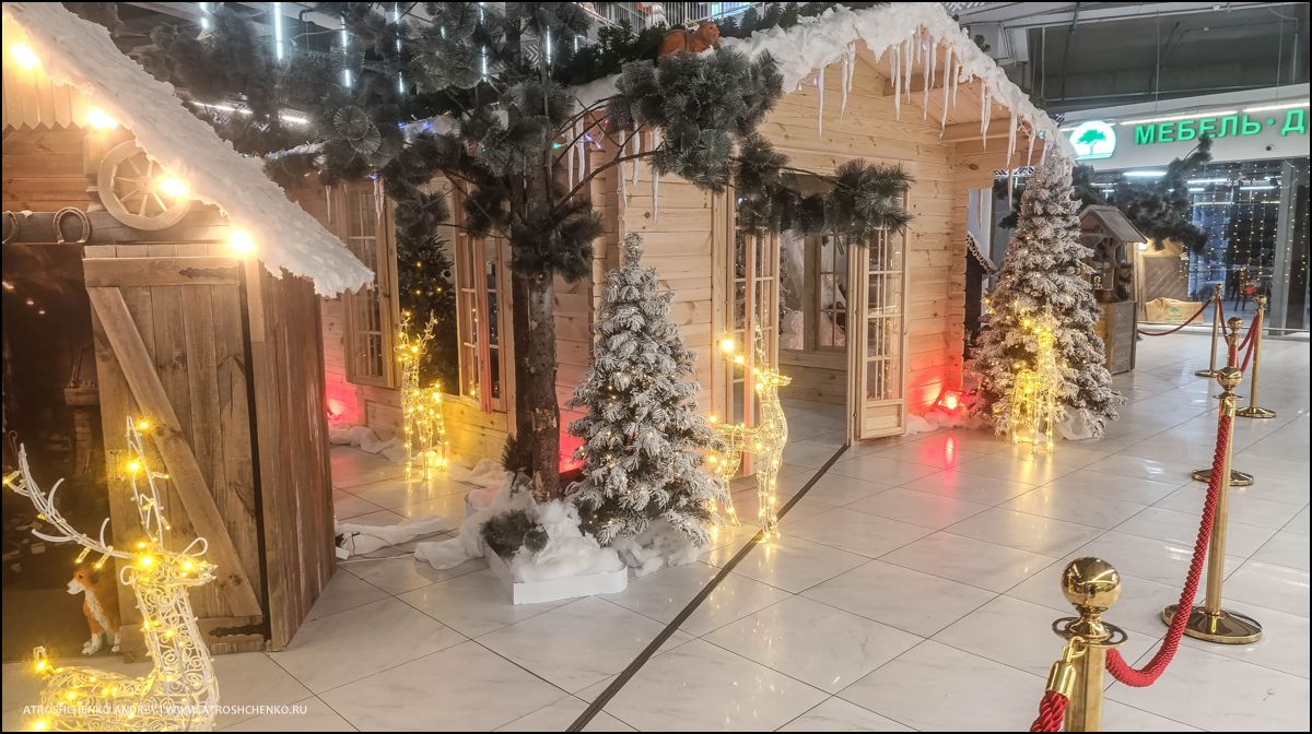 Фотозона с рождественскими санями и елками внутри гипермаркета Перши