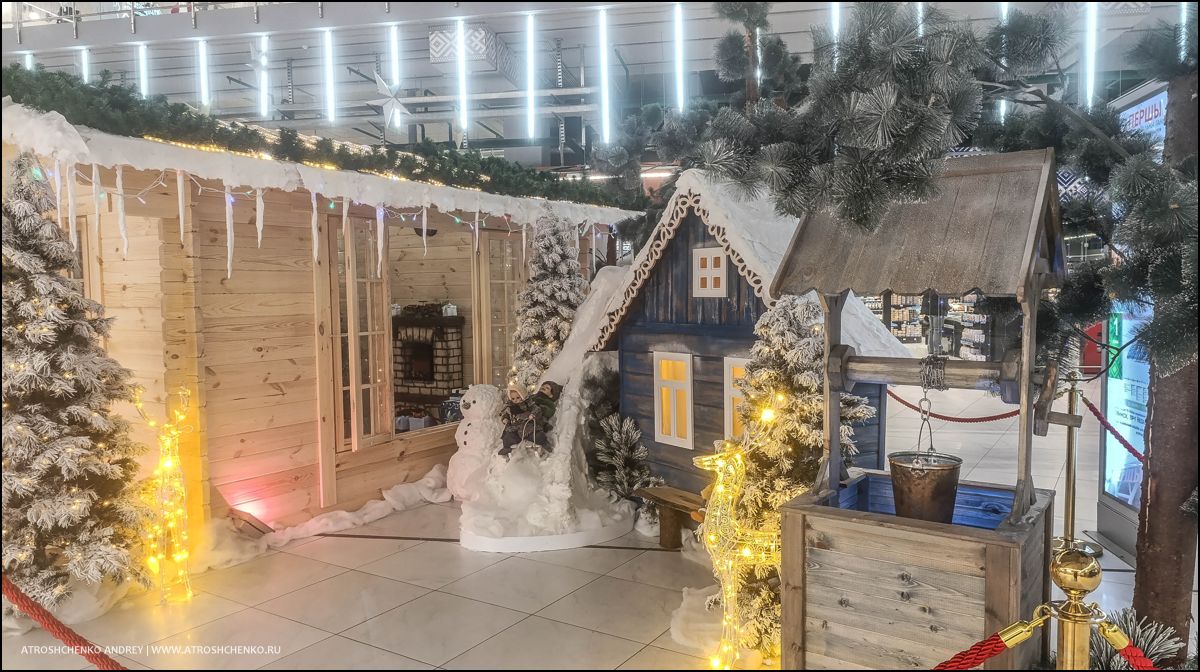 Фотозона с рождественскими санями и елками внутри гипермаркета Перши