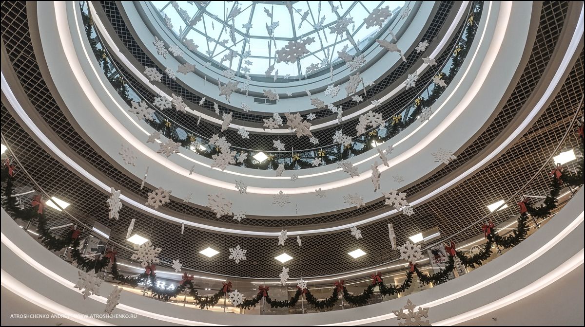 Фотозона с рождественскими санями и елками внутри гипермаркета Перши